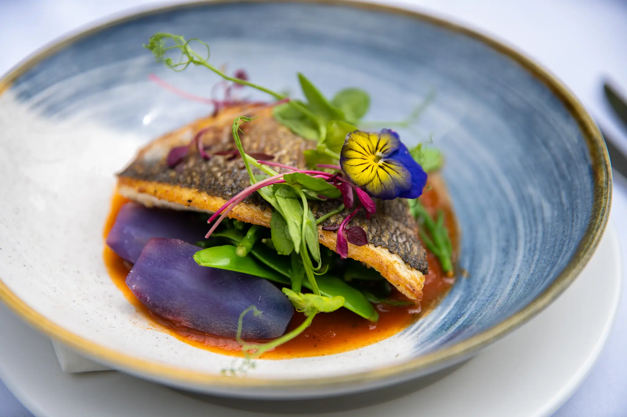 A fish course in a blue bowl from the restaurant