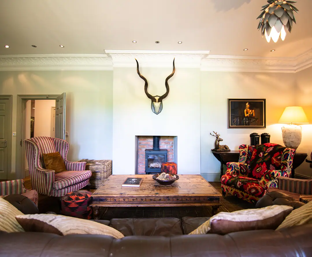 A sitting room with a fireplace and antlers on the wall