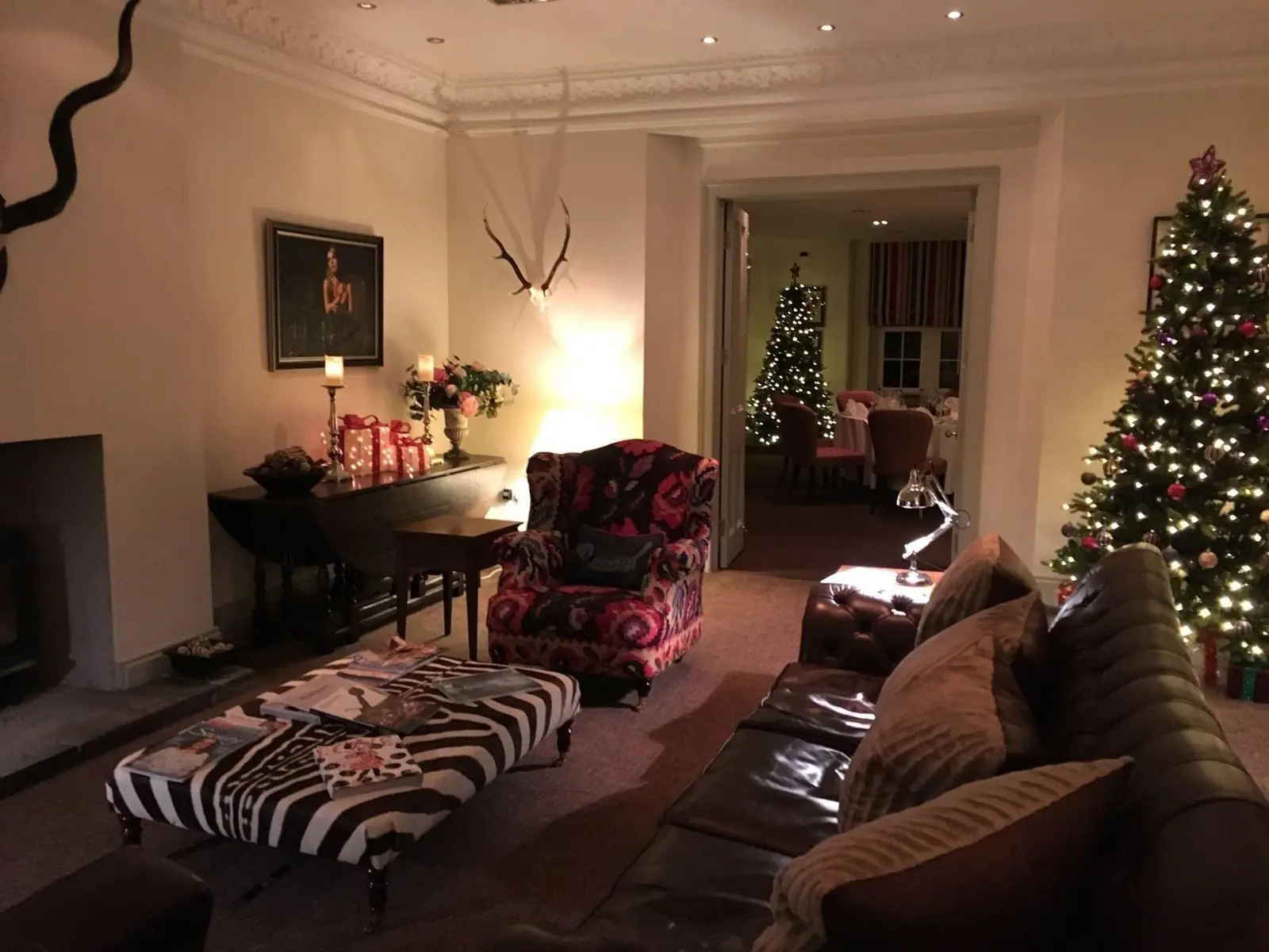 A sitting room with lit Christmas trees