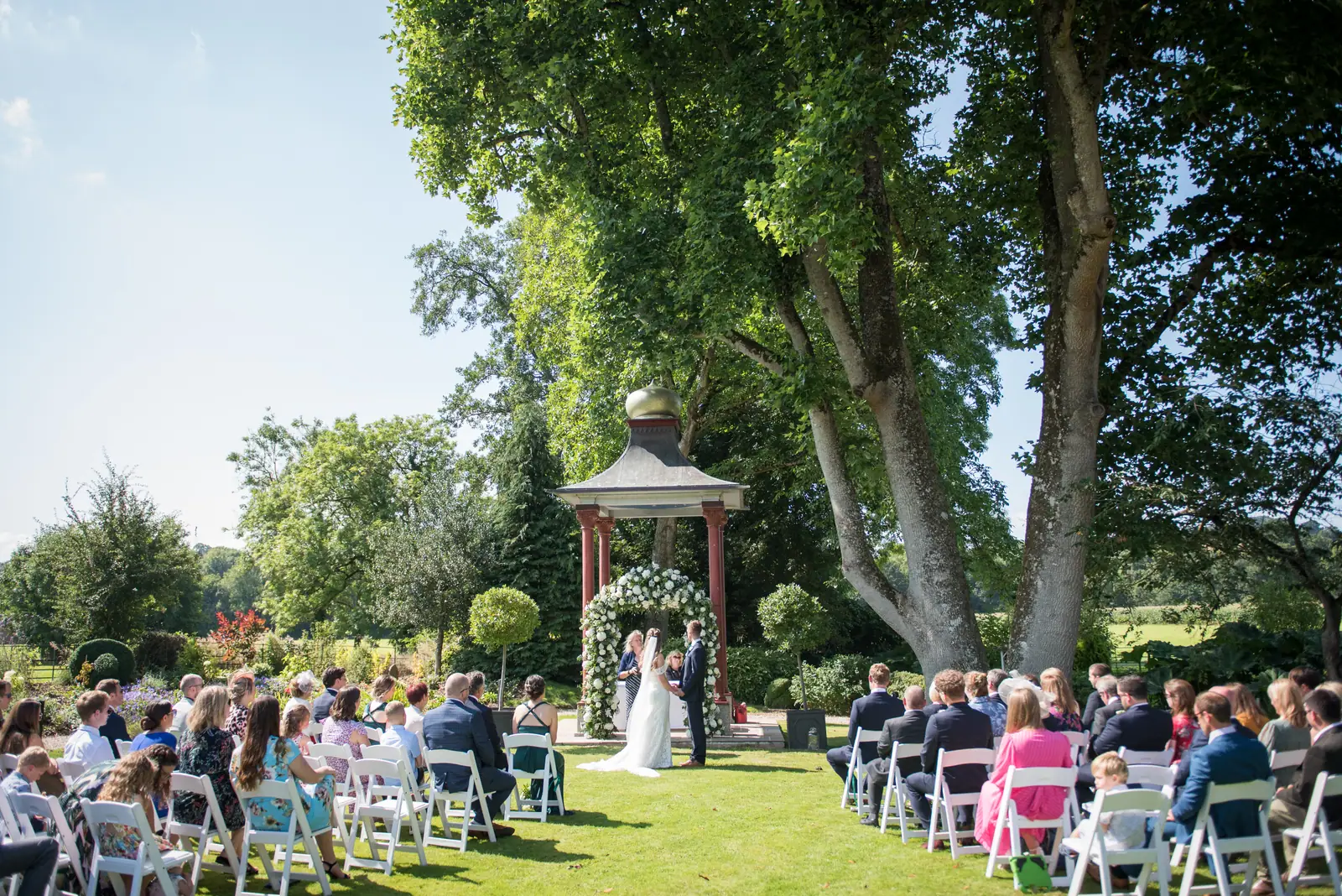 A ceremony at the Pergoda, guests seated on the lawn